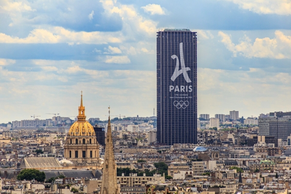 Un rascacielos moderno con el logotipo de París domina la ciudad